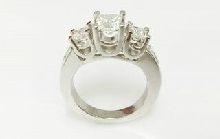 Mary platinum three stone ring with side diamonds front view